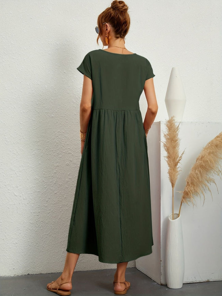 Comfortable women's flowy maxi dress modeled. Features convenient pockets & a loose fit, ideal for summer.