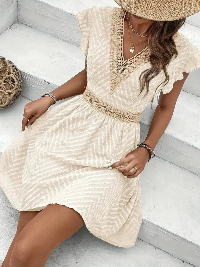 Comfortable women's mini dress with flutter sleeves & V-neck, a casual summer dress with a flowy flared skirt.