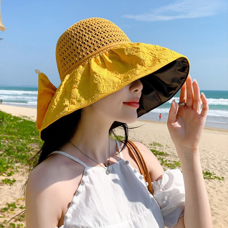 Back view of a women's foldable wide-brim sun hat, showing the bow from behind.
