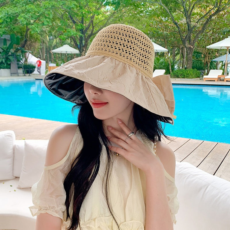 Outdoor shot of a women's foldable wide-brim sun hat with a bow, providing excellent shade.