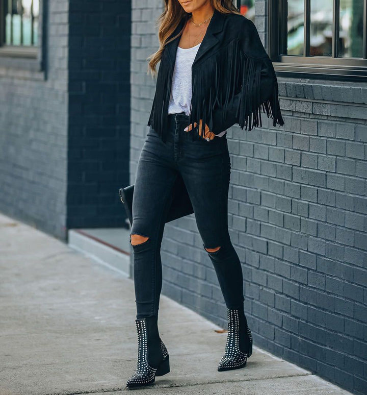 Fashionable woman wearing a statement fringed suede moto jacket, side profile