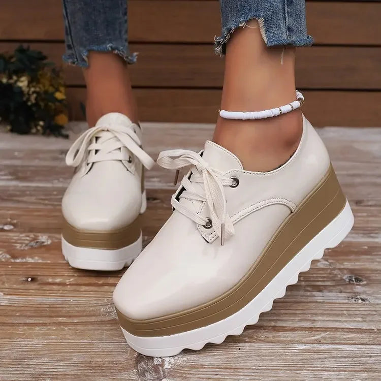 Product photo of women's glossy platform sneakers, highlighting the blend of fashion and orthopedic support.