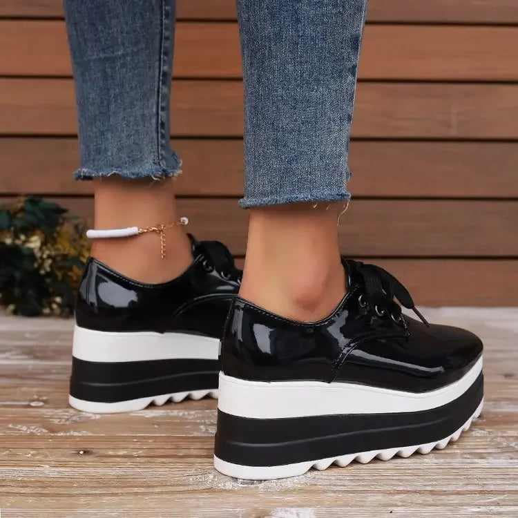 Close-up of the sole of women's glossy platform sneakers, showing grip and platform height for comfort.