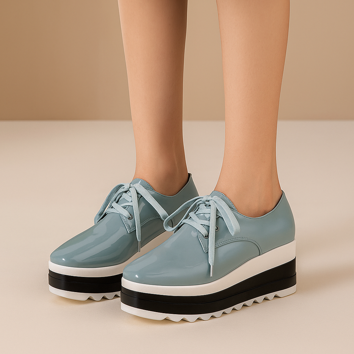 Pair of women's glossy platform sneakers, top-down view, showcasing lace-up design and orthopedic insole.