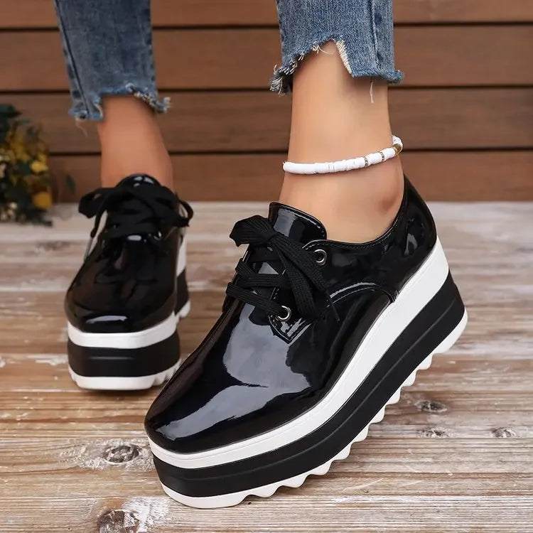Side profile of glossy platform sneakers for women, illustrating elevated sole and modern design.