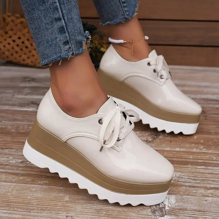 Back view of women's glossy platform sneakers, highlighting heel detailing and durable construction.