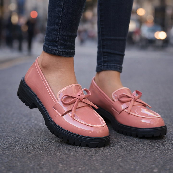Side profile of a women's patent leather penny loafer, highlighting its sleek design