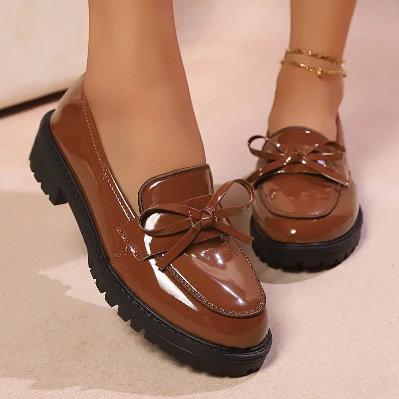 Women's black patent loafers on a white background, ready for casual or dressy outfits