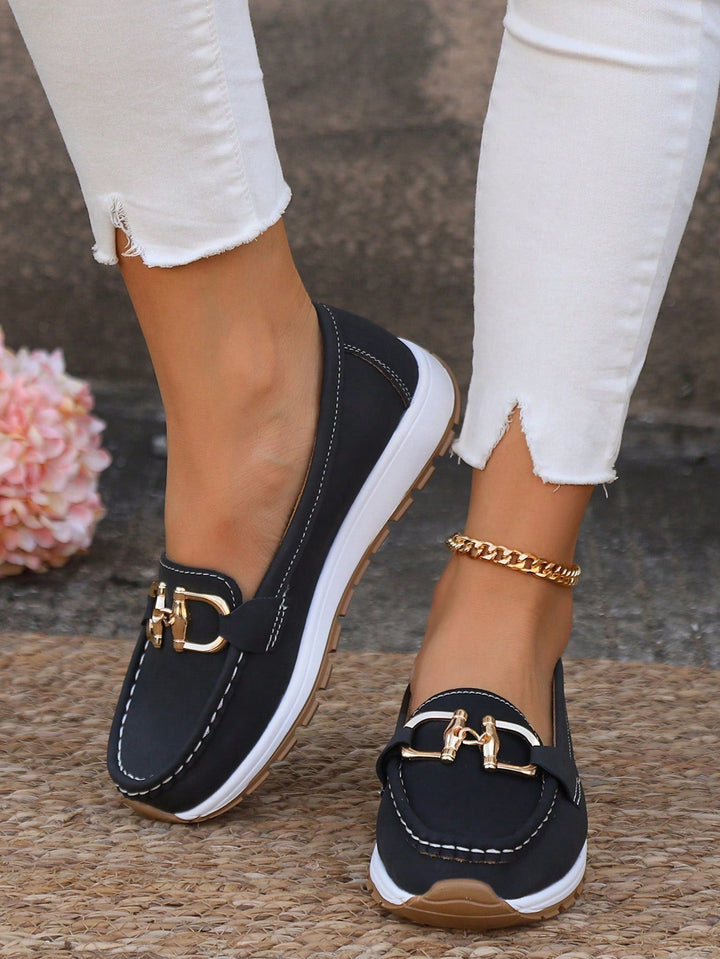 Black slip-on women's loafers with a prominent gold buckle, designed for all-day comfort and style.