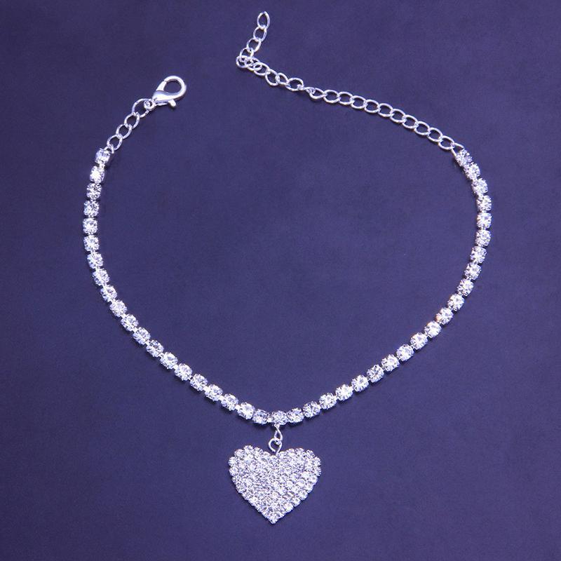 Sparkling rhinestone heart charm on a women's copper anklet, a trendy foot accessory for summer.