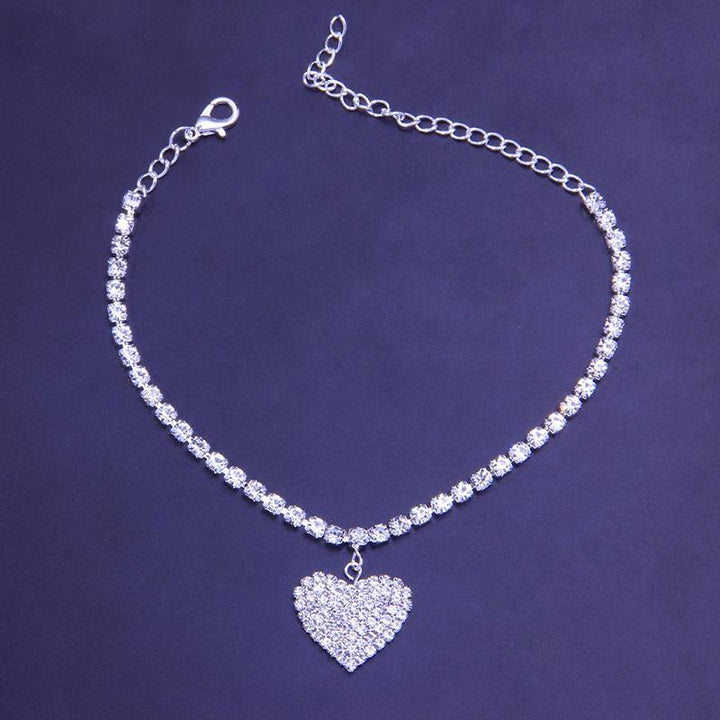 Sparkling rhinestone heart charm on a women's copper anklet, a trendy foot accessory for summer.