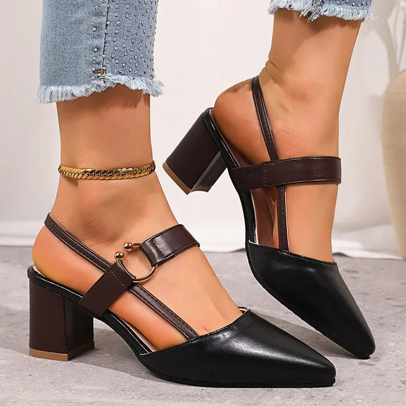 Chic women's block heels in black leather, golden ring embellishment, perfect for dressy ensembles.