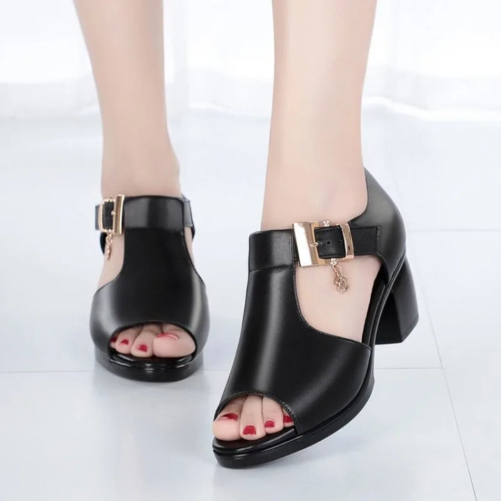 Detail shot of the sturdy block heel on a women's open-toe pump with buckle closure.