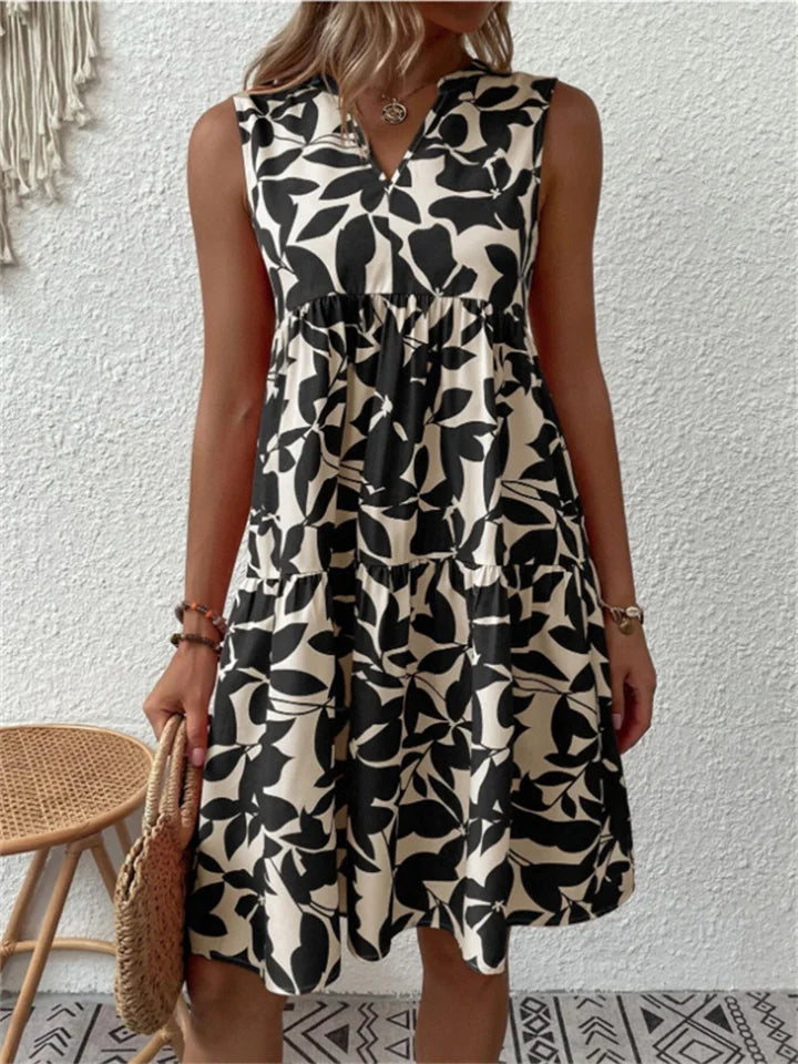 Women's flowing leaf print V-neck mini dress. Tiered sleeveless design offers effortless summer vacation style.