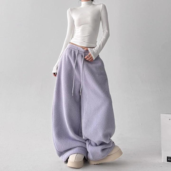 Lifestyle shot of women's wide-leg fleece lounge pants, emphasizing their flowy and relaxed fit