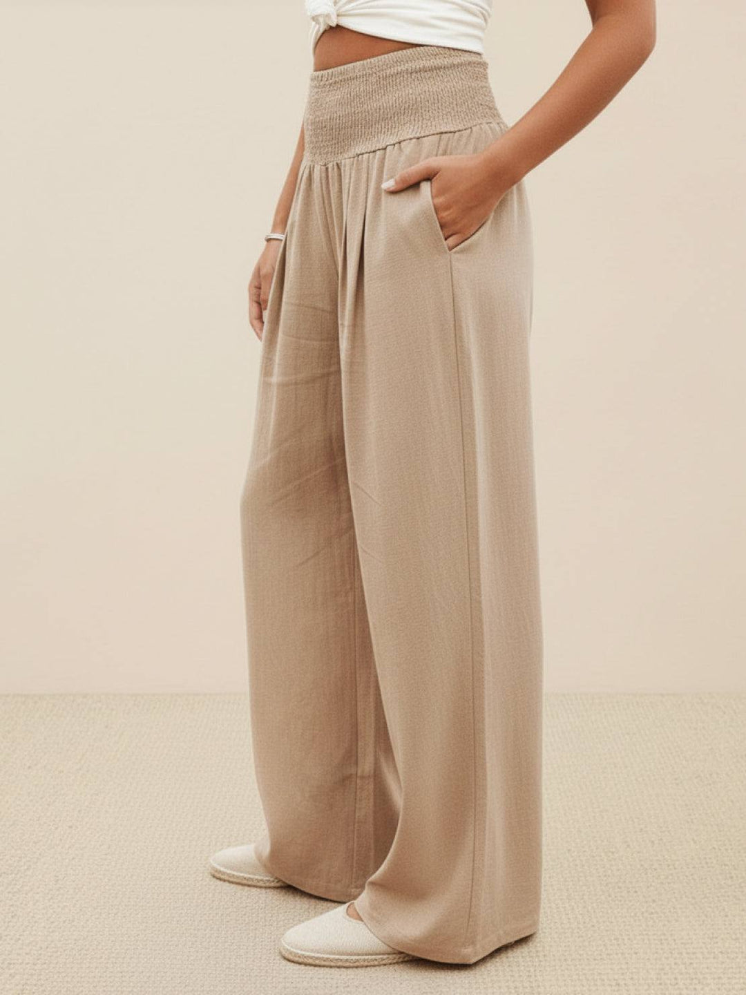 Chic women's wide leg pants featuring a high smocked waist, perfect for spring fashion.
