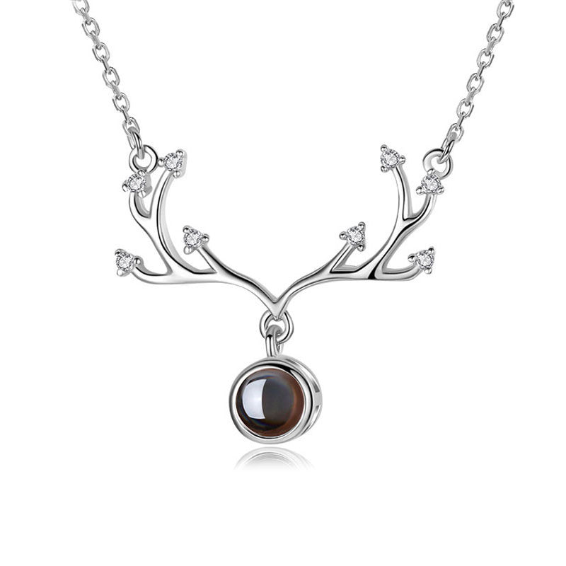 The '100 Languages I Love You' projection necklace in rose gold, capturing light beautifully.