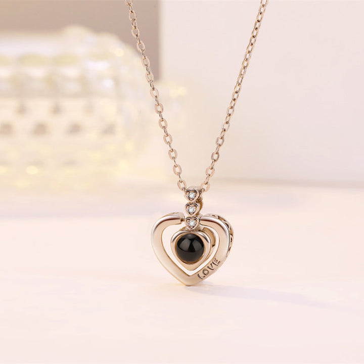 Heart-shaped rose gold 'I Love You' projection necklace, a unique and meaningful anniversary gift.