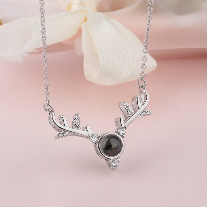 The '100 Languages I Love You' projection from a rose gold heart pendant, illuminating words.