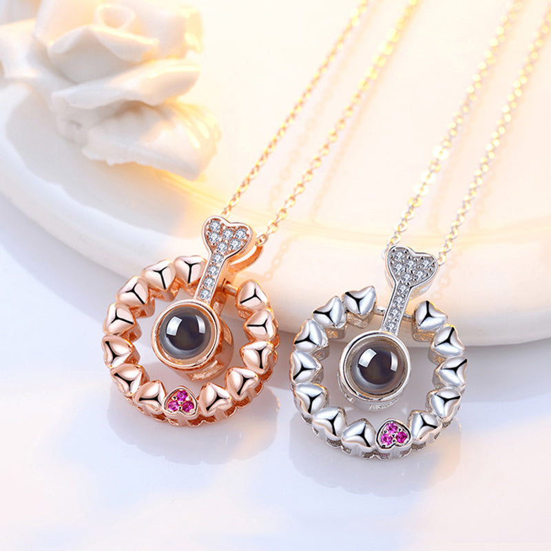 Women's 'I Love You' projection necklace, rose gold, with a delicate chain and heart pendant.