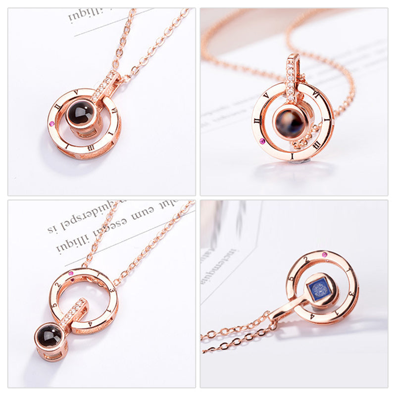 A woman's hands gently holding a silver 'I Love You' projection pendant necklace.