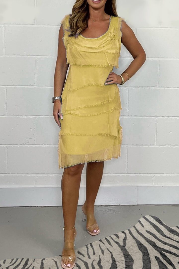 Woman in stylish Ilaira chic sleeveless frayed mini dress, enjoying a sunny day, perfect versatile summer fashion.