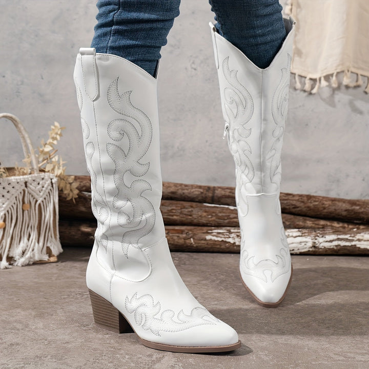Elegant white knee-high cowboy boots for women, featuring a block heel & pointed toe.