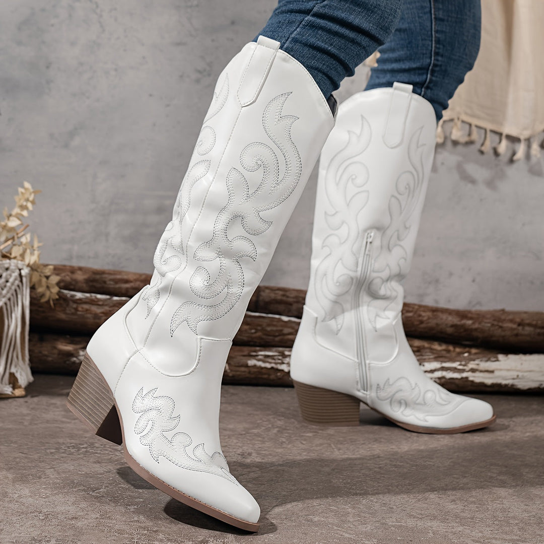 White fashion cowboy boots. Women's knee-high, block heel, with a trendy pointed toe.