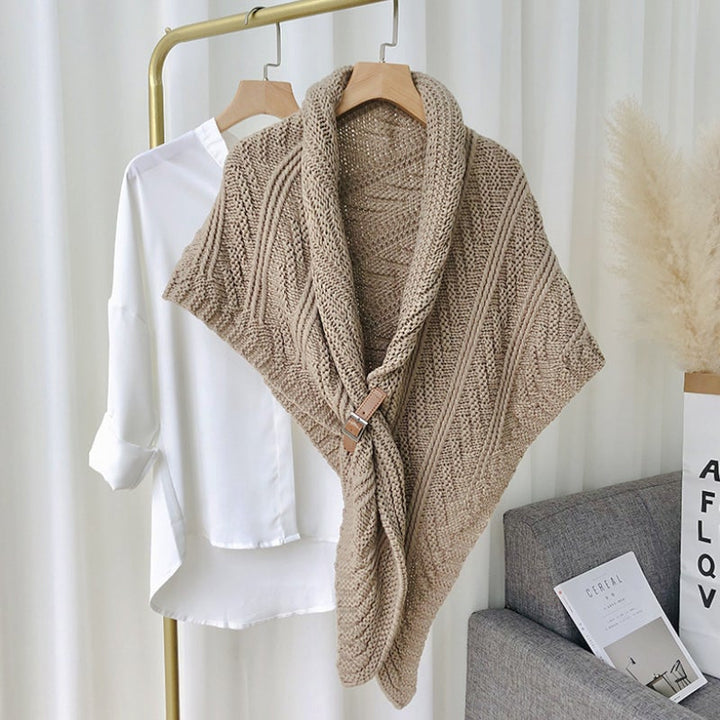 Woman wearing a cream knitted triangle shawl, draped elegantly as a poncho