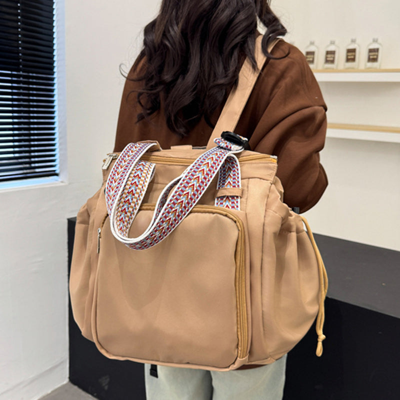 Woman wearing a large capacity black nylon tote backpack, perfect for travel