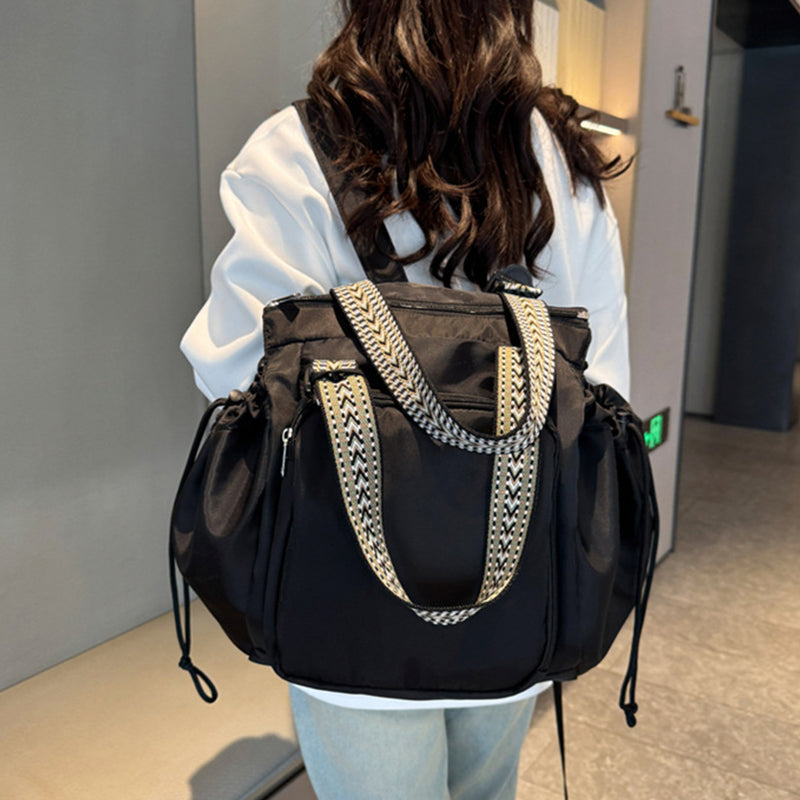 Side view of women's large capacity tote backpack, showing expandable design