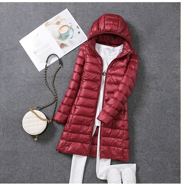 Women's lightweight long puffer jacket with a stylish detachable hood, perfect for fall and winter.