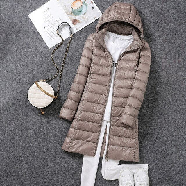 Stylish women's lightweight long puffer jacket, featuring a detachable hood, excellent for cold weather.