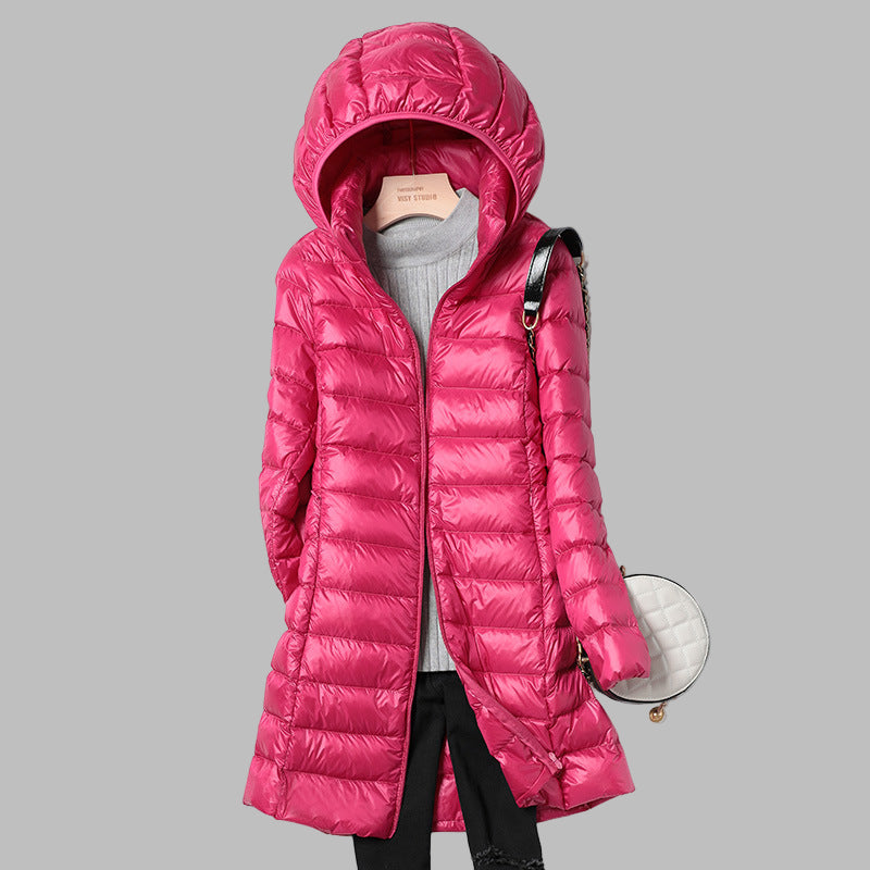 Modern women's long puffer jacket with a removable hood, a lightweight and warm choice for fall and winter.