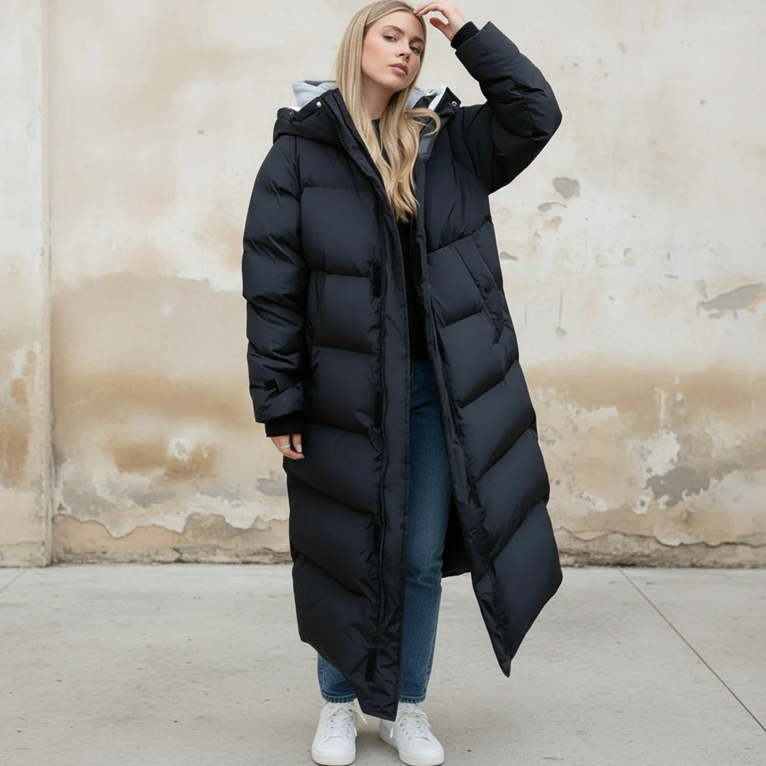 Fashionable women's long hooded puffer jacket, ideal for cold weather. Warm, insulated winter coat in a sleek design.