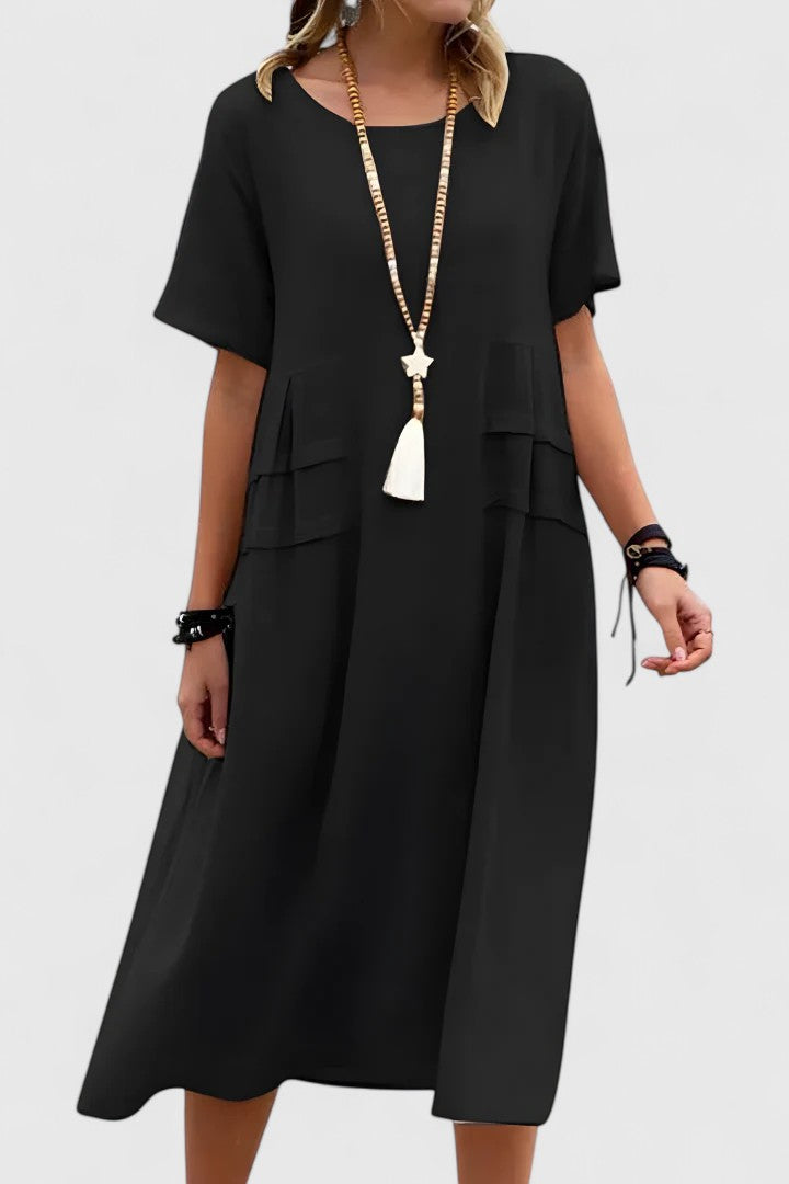 Relaxed women's midi dress, loose fit & short sleeves. Features practical pockets. Comfortable and versatile summer style.