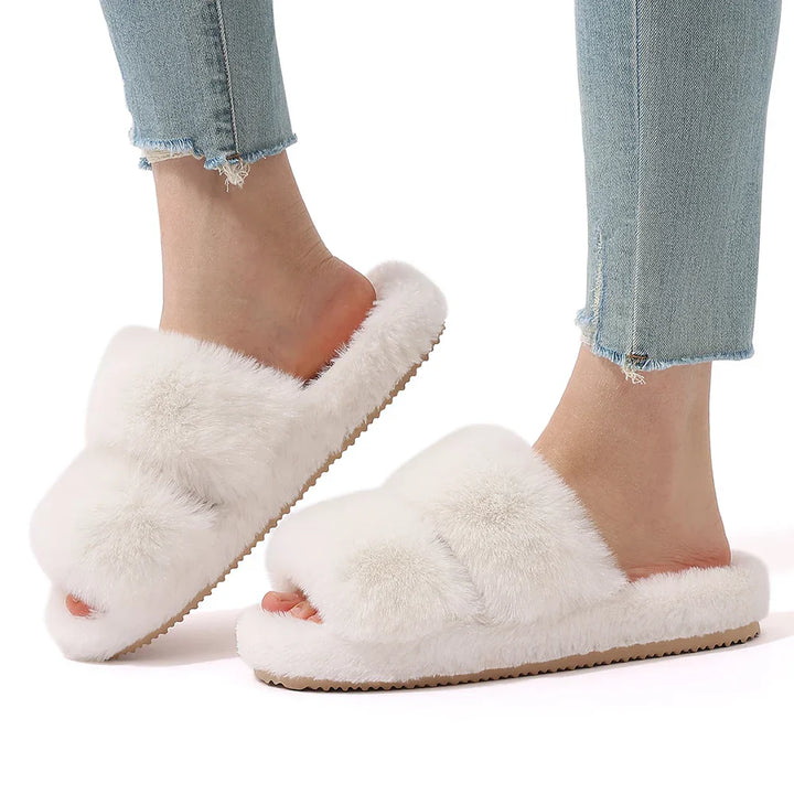 White background product image of women's beige faux fur slide slippers, emphasizing their plush design.