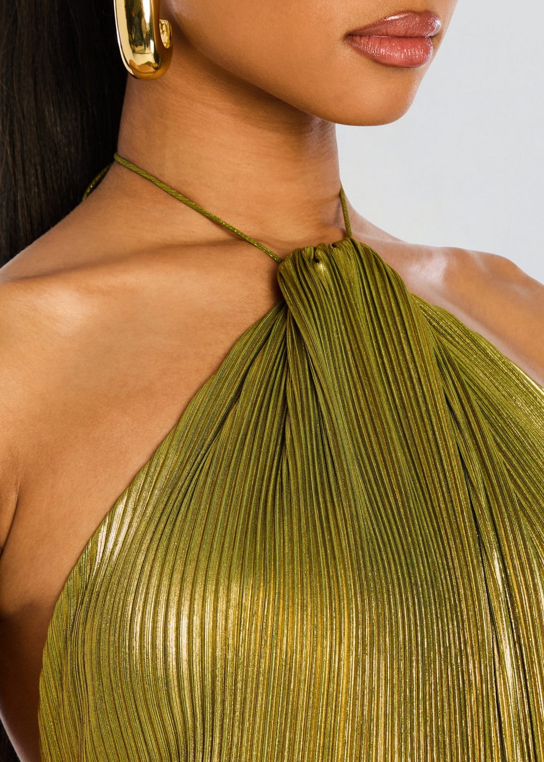 Formal women's metallic green maxi dress with a halter top and pleated skirt, perfect as a wedding guest gown.