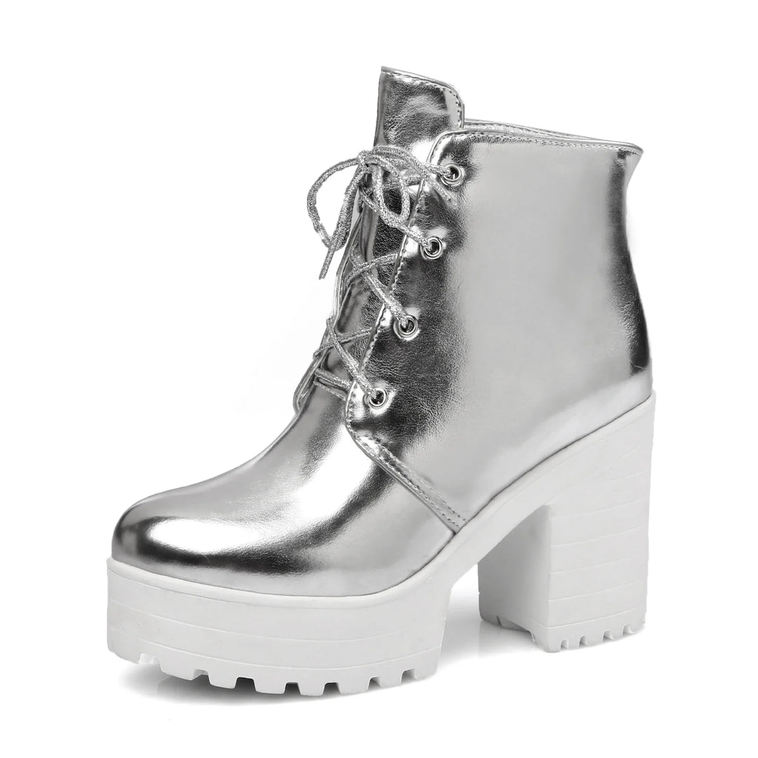 Studio shot of women's metallic platform boots, lace-up design with chunky sole, on white background.