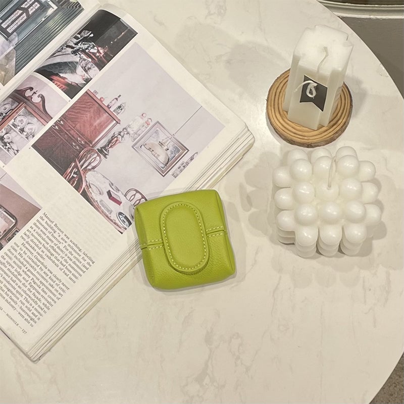 A small collection of change inside a mini brown leather coin purse, practical storage