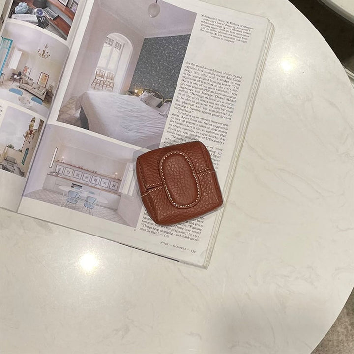 Mini black leather coin purse with a subtle brand logo, discreet elegance