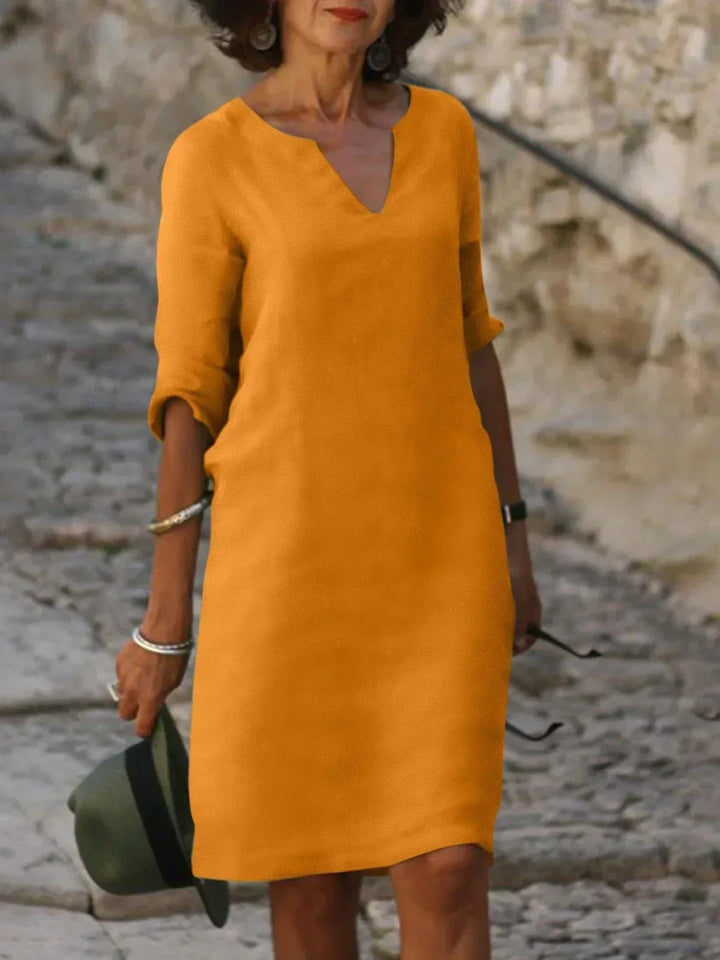 Plus size women's loose fit mini dress, featuring 3/4 sleeves & V-neck for comfy summer style.