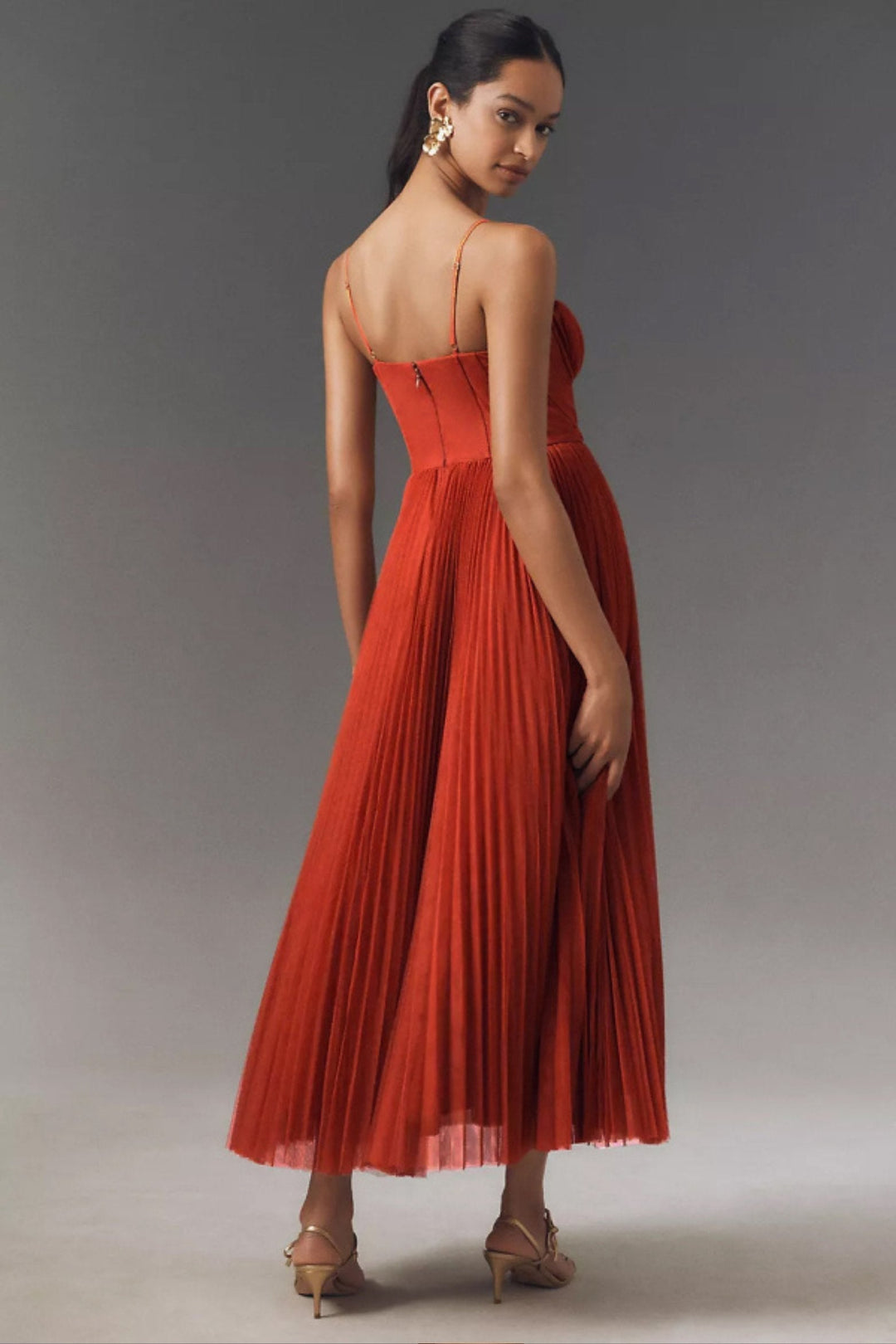 Beautiful women's one-shoulder flowing midi wedding guest dress, made from elegant pleated tulle. A formal choice.