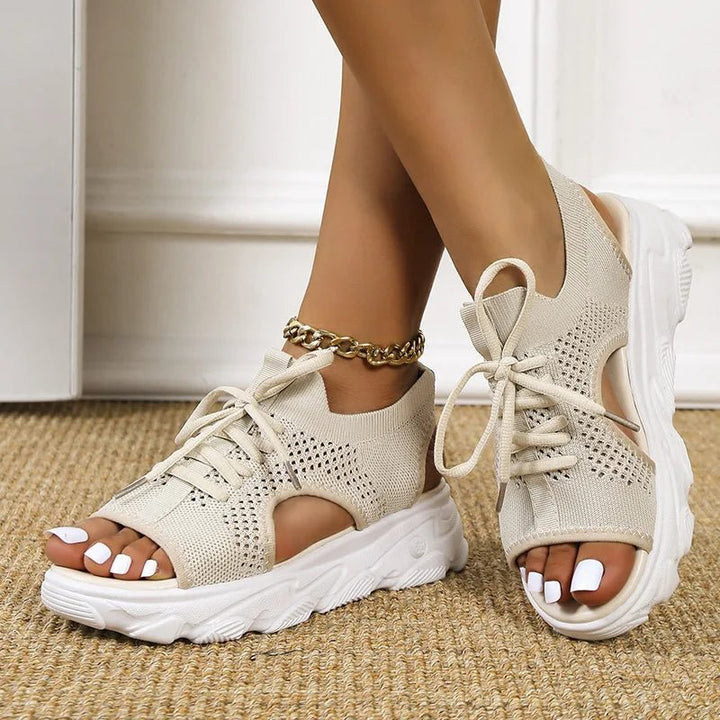 Woman wearing stylish open-toe platform sandals, lace-up design, perfect for summer and casual outings.