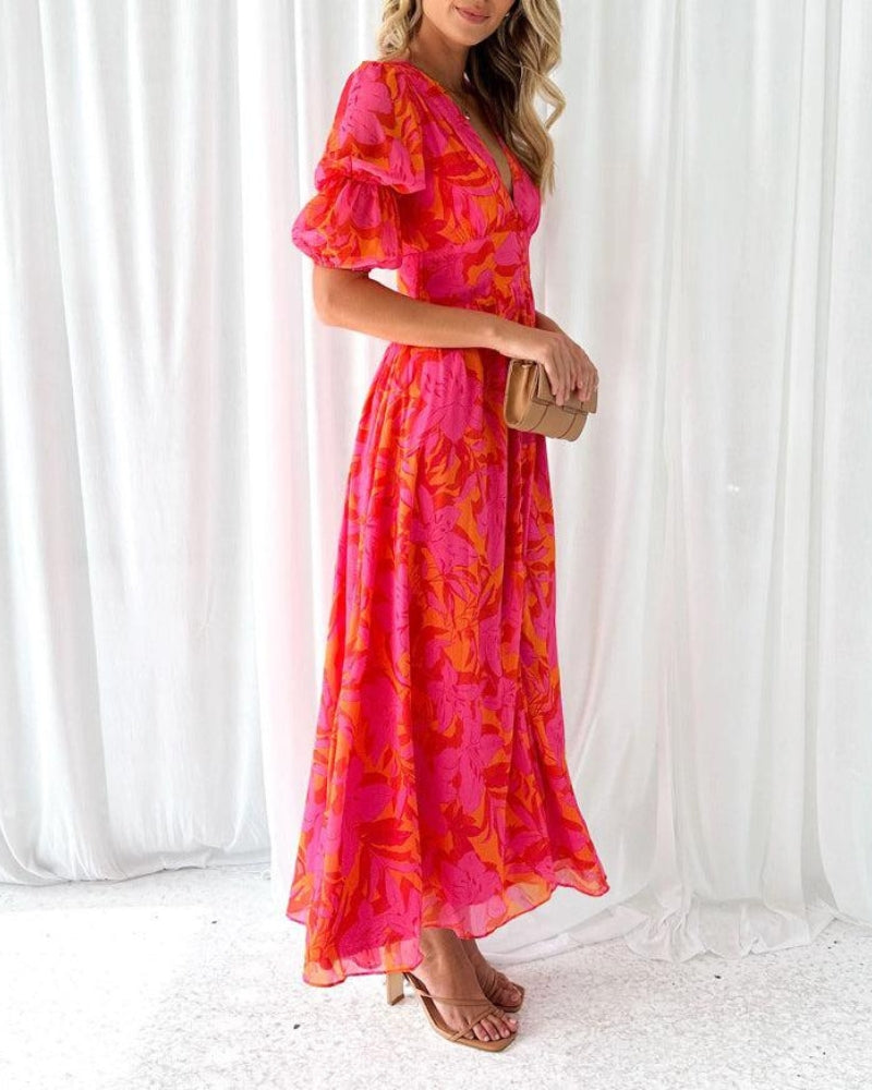 Flowing women's maxi dress in orange print, featuring a flattering V-neck and trendy puff sleeves for elegant casual wear.
