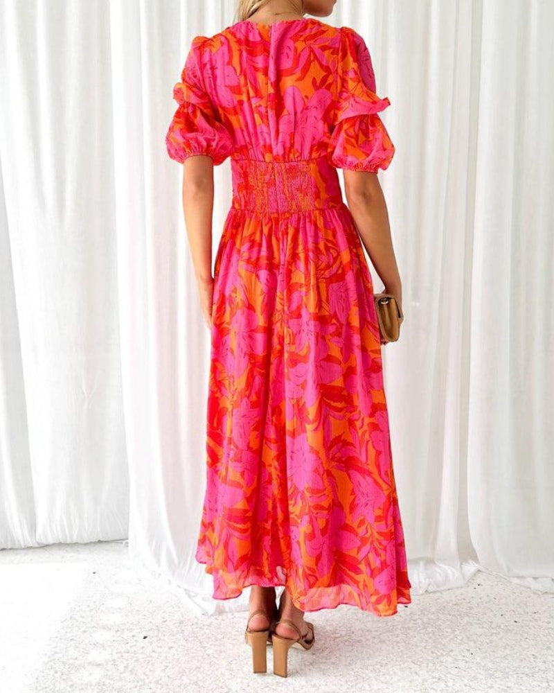 Stylish orange printed maxi dress for women, showcasing a deep V-neck and dramatic puff sleeves, ideal as a statement summer dress.