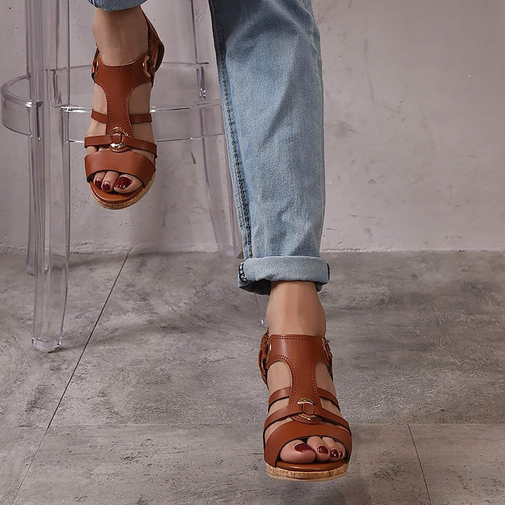 Woman wearing stylish orthopedic wedge sandals, demonstrating comfortable foot support.
