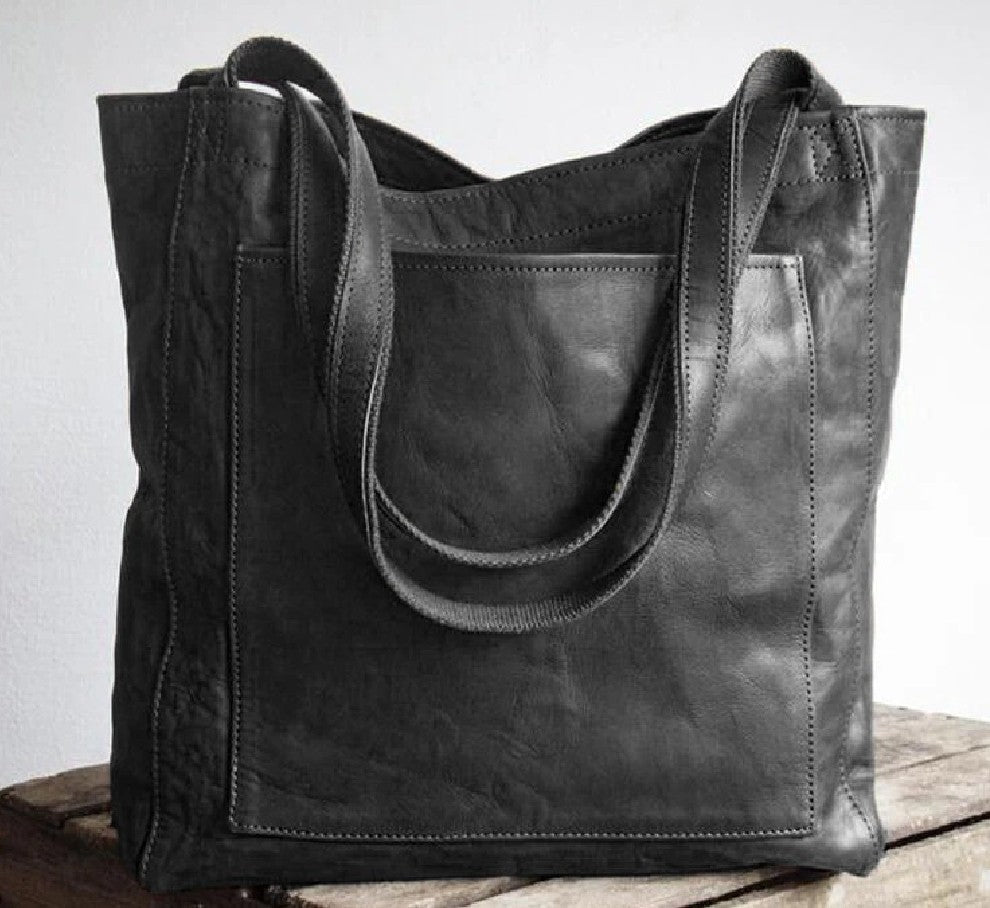 Luxurious grain leather shoulder bag for women, an oversized tote with a prominent external pocket.