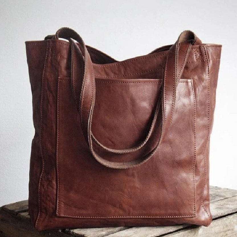 Stylish women's work or travel bag: oversized leather tote handbag featuring a large external pocket.