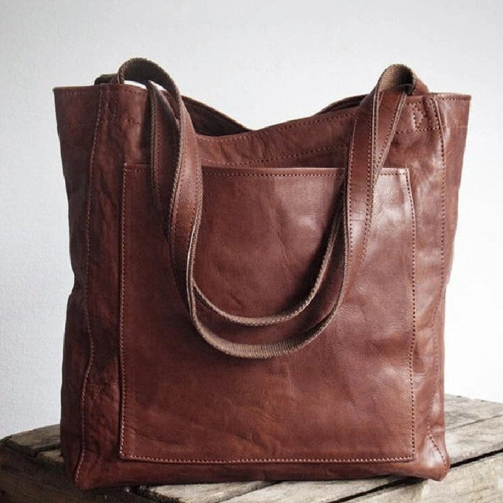 Stylish women's work or travel bag: oversized leather tote handbag featuring a large external pocket.